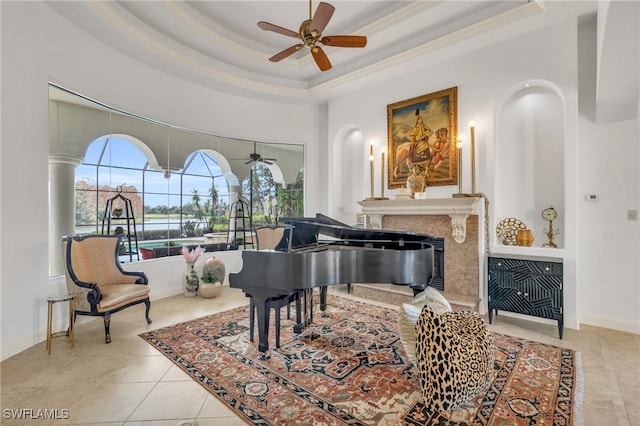 sitting room featuring crown molding, ceiling fan, light tile patterned floors, and a raised ceiling