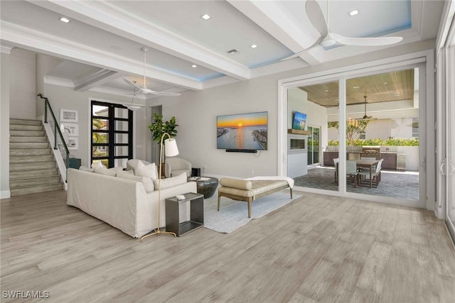 living room with light hardwood / wood-style floors, beamed ceiling, and ceiling fan