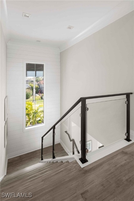 staircase featuring brick wall and hardwood / wood-style floors