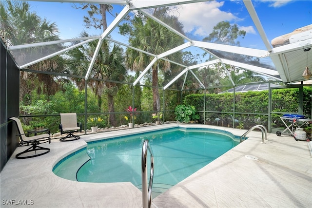 view of pool with a patio area and glass enclosure