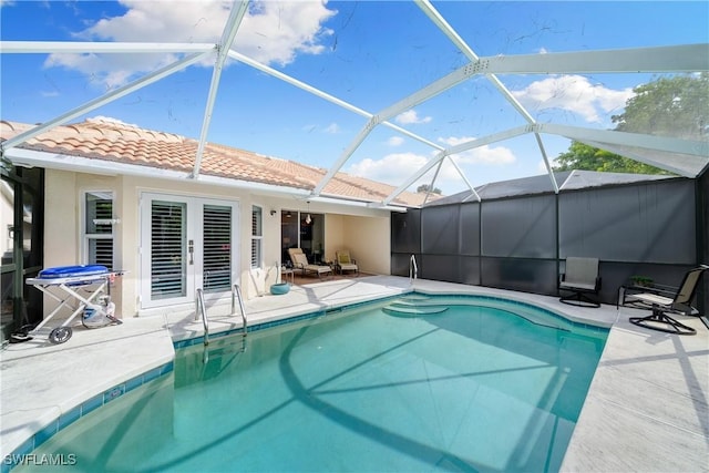 view of swimming pool with glass enclosure and a patio area