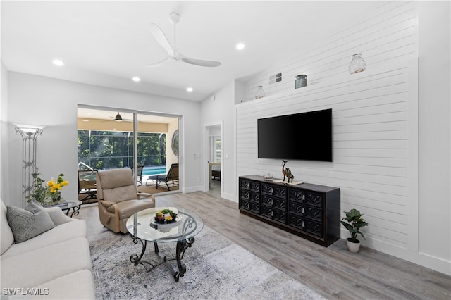 living room with light hardwood / wood-style floors, lofted ceiling, and ceiling fan