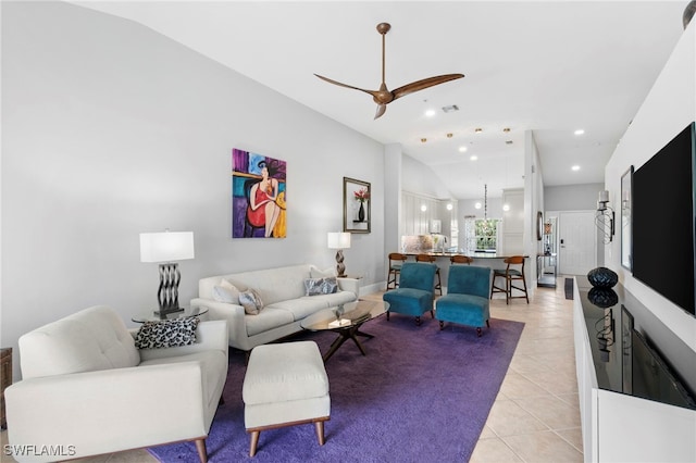 tiled living room with ceiling fan and vaulted ceiling