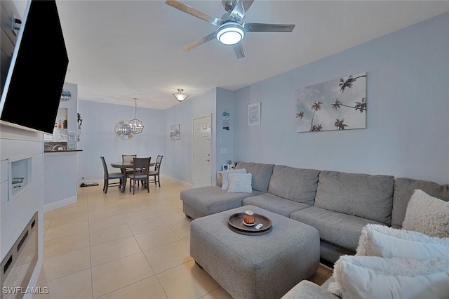 tiled living room with ceiling fan with notable chandelier