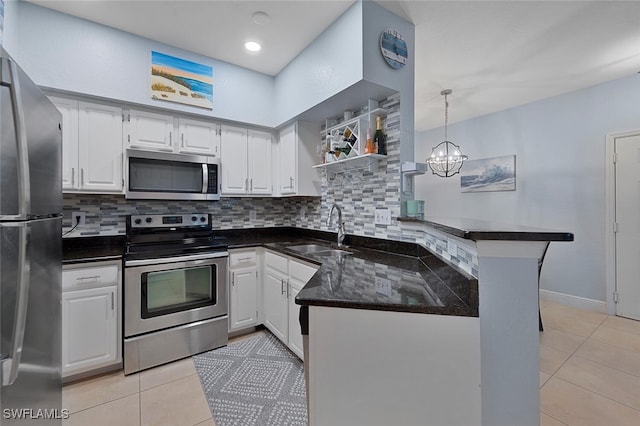 kitchen with white cabinetry, stainless steel appliances, sink, and kitchen peninsula