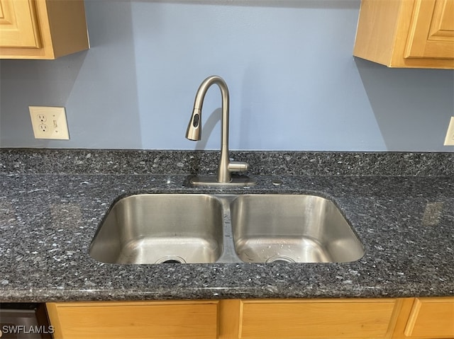 details with sink, light brown cabinets, and dark stone counters