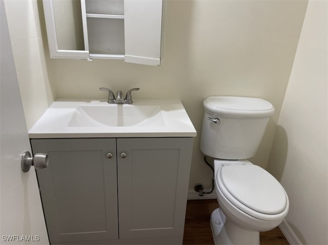 bathroom featuring vanity, hardwood / wood-style floors, and toilet