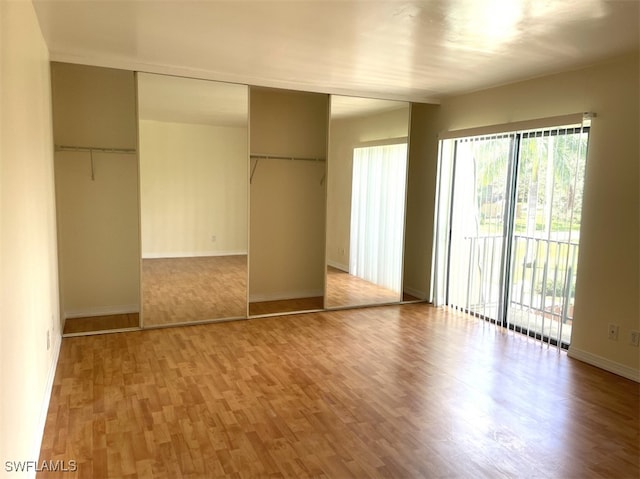 unfurnished bedroom with a closet and hardwood / wood-style flooring