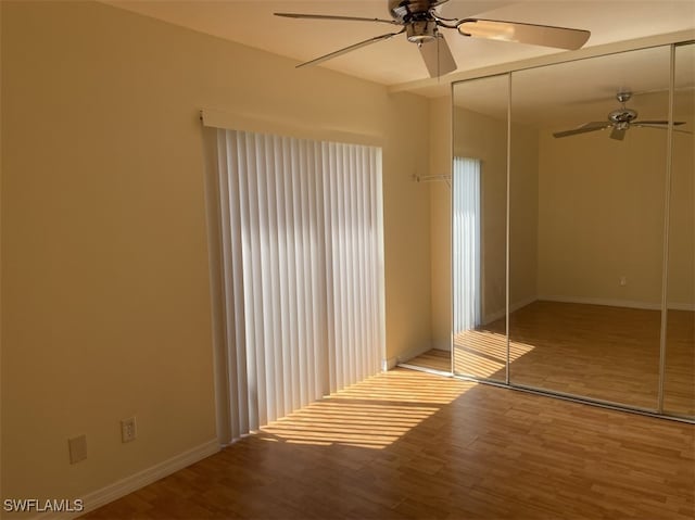 unfurnished bedroom featuring light hardwood / wood-style floors, a closet, and ceiling fan