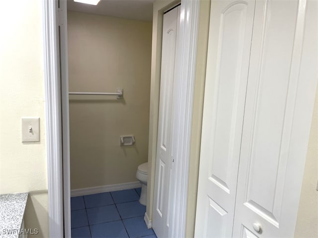 bathroom with toilet, vanity, and tile patterned flooring