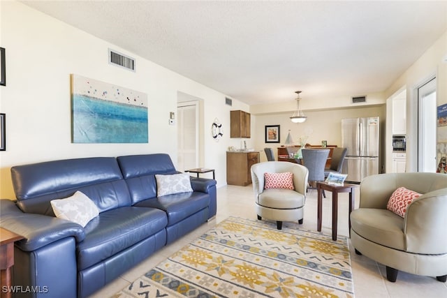 living room with light tile patterned flooring and a textured ceiling