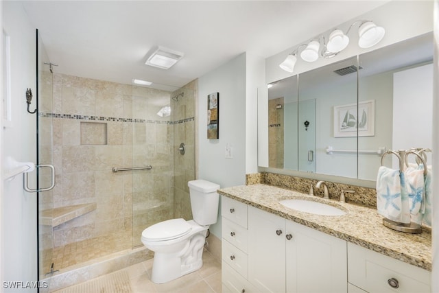 bathroom with tile patterned flooring, vanity, a shower with shower door, and toilet