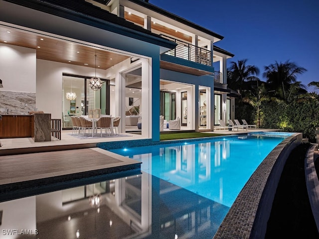 view of pool at twilight