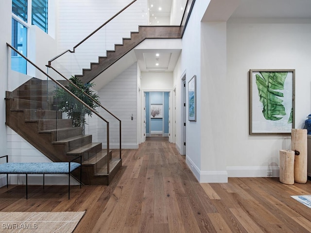 entryway with a high ceiling and wood-type flooring