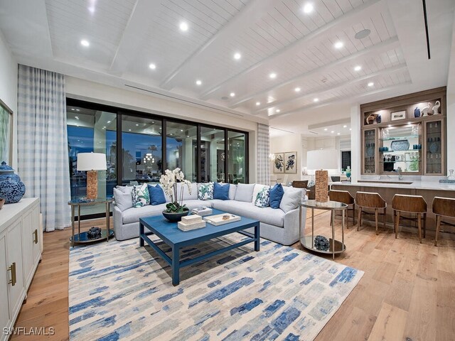 living room featuring beamed ceiling and light wood-type flooring