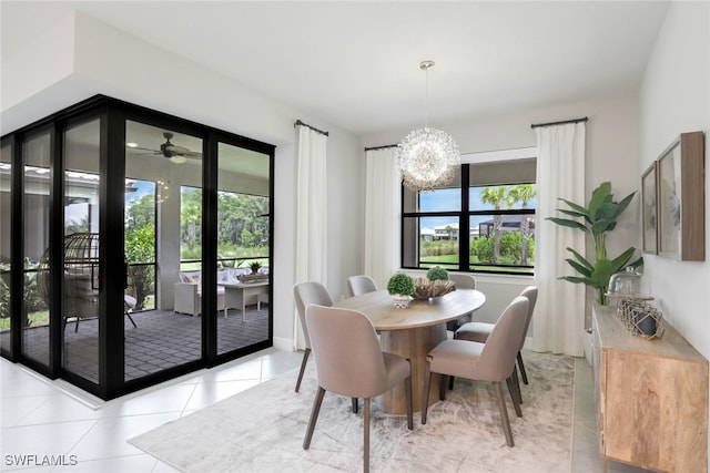 dining area with plenty of natural light, light tile patterned flooring, and ceiling fan with notable chandelier