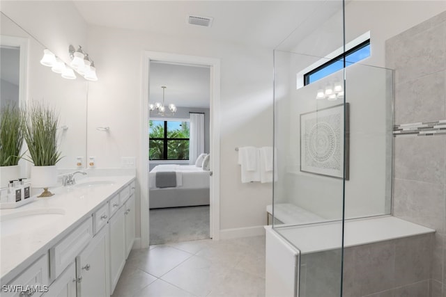 bathroom featuring tile patterned floors, vanity, tiled shower, and an inviting chandelier