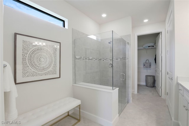 bathroom featuring tile patterned flooring, vanity, an inviting chandelier, and a shower with door