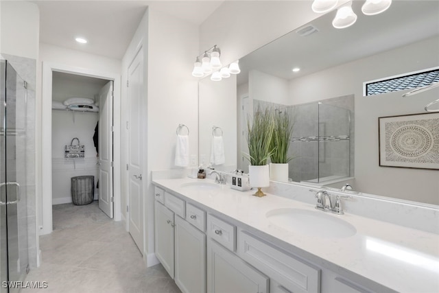 bathroom with tile patterned floors, vanity, and a shower with door