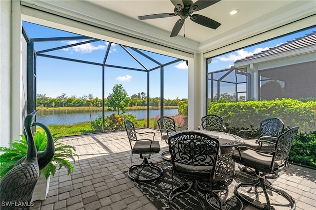 view of patio / terrace with ceiling fan, a lanai, and a water view