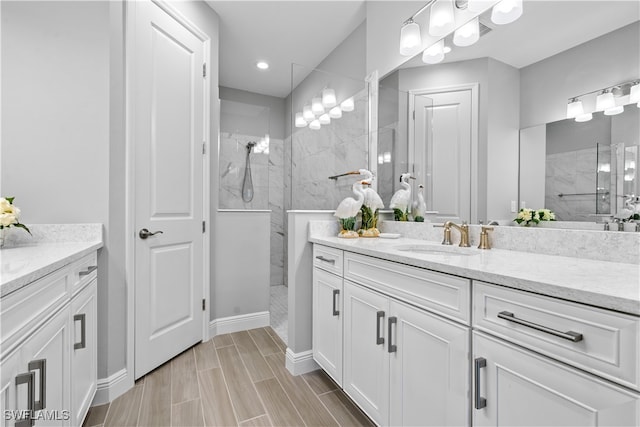 bathroom featuring tiled shower and vanity