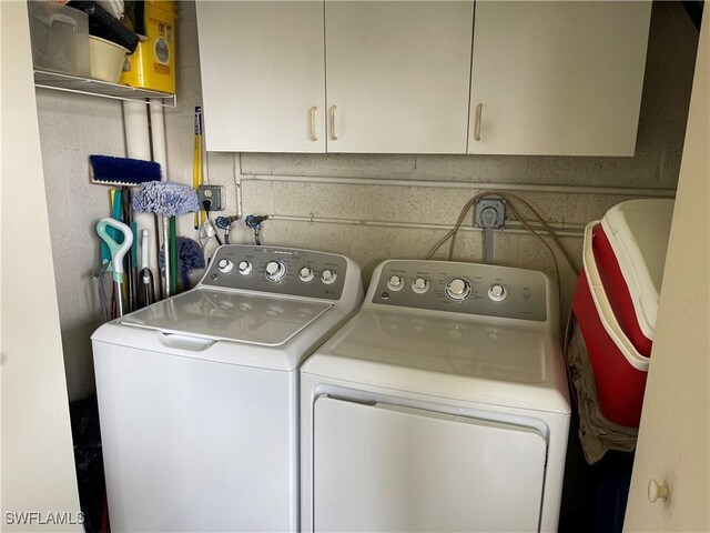 washroom with washer and clothes dryer and cabinets