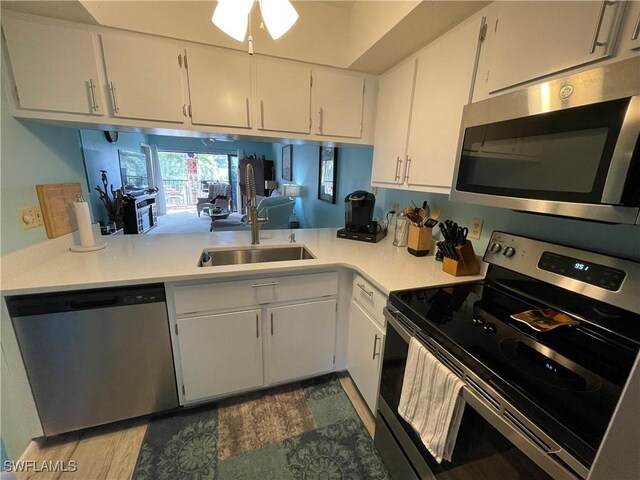 kitchen featuring appliances with stainless steel finishes, sink, white cabinets, and ceiling fan