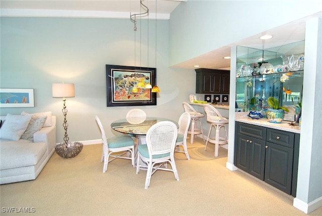 dining room featuring a high ceiling and light colored carpet