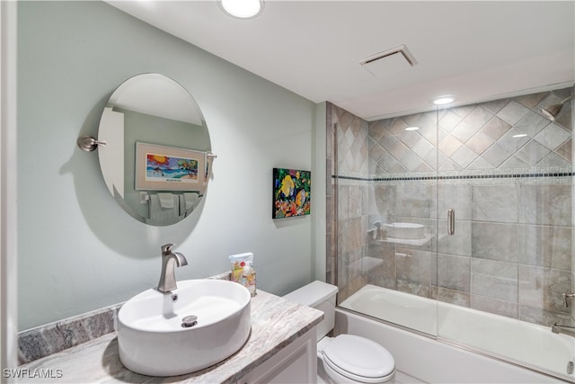 full bathroom featuring toilet, vanity, and shower / bath combination with glass door