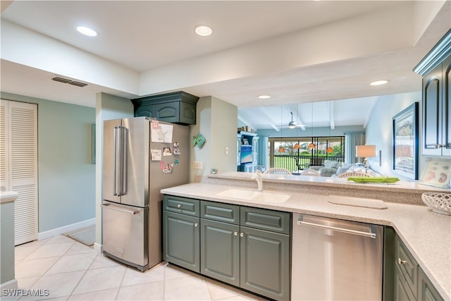 kitchen featuring appliances with stainless steel finishes, lofted ceiling, sink, and light tile patterned floors