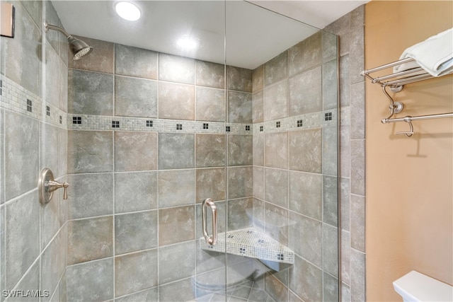 bathroom featuring toilet and an enclosed shower