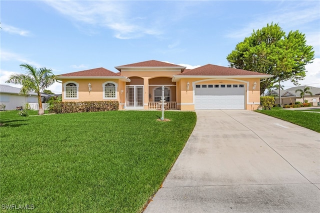 mediterranean / spanish home featuring a front lawn and a garage