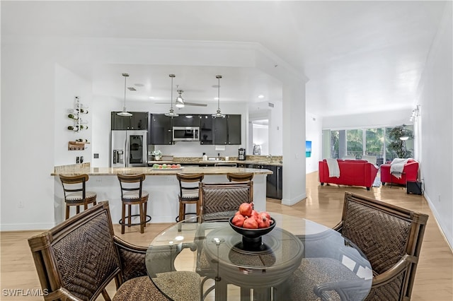 dining space with light hardwood / wood-style flooring and ceiling fan