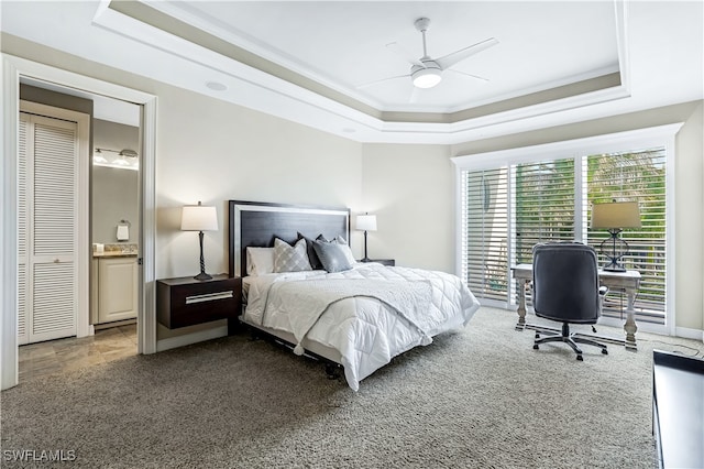 carpeted bedroom with crown molding, ceiling fan, a raised ceiling, and connected bathroom