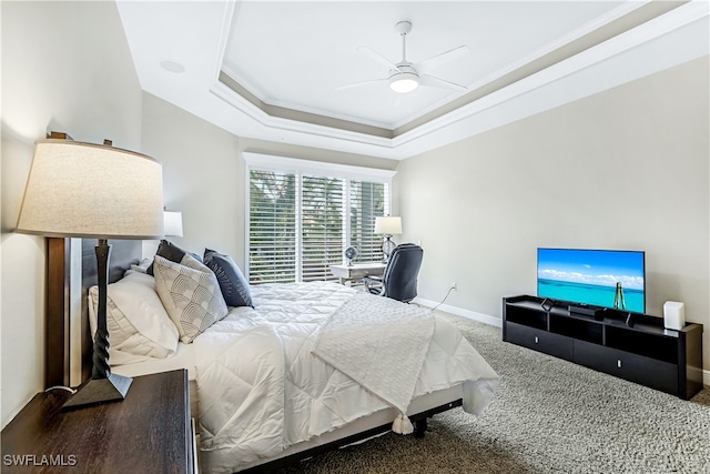 bedroom with a tray ceiling, carpet, and ceiling fan