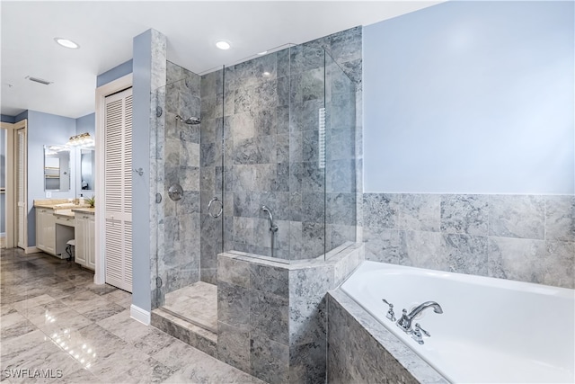 bathroom featuring vanity and independent shower and bath