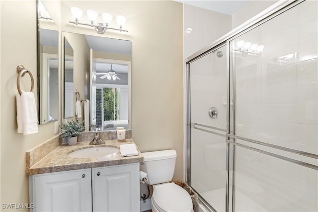 bathroom with walk in shower, vanity, ceiling fan, and toilet