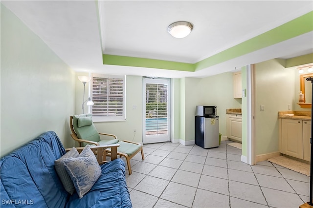 sitting room featuring a tray ceiling and light tile patterned floors