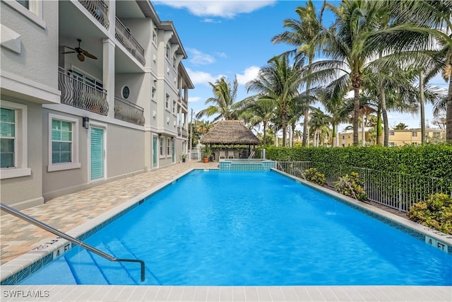 view of pool featuring ceiling fan, a gazebo, and pool water feature