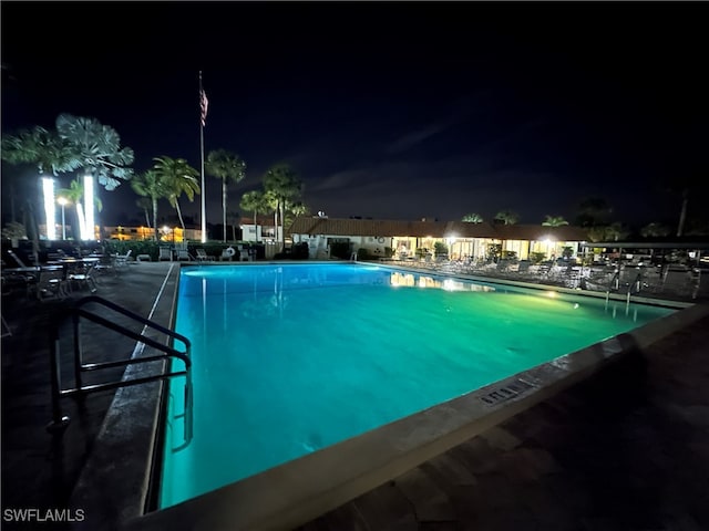 view of pool at twilight