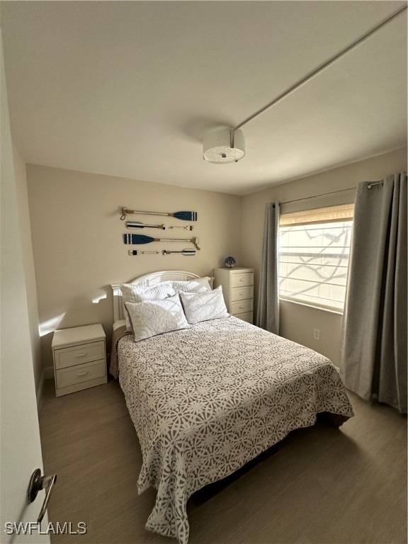 bedroom with dark hardwood / wood-style floors