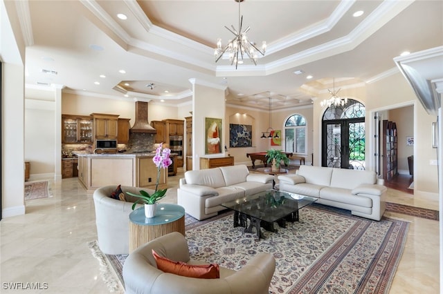 living room with crown molding, a tray ceiling, and a chandelier