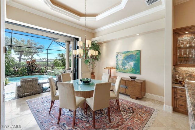 dining room with a tray ceiling, ornamental molding, and an inviting chandelier