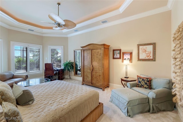 carpeted bedroom with ornamental molding, a tray ceiling, and ceiling fan