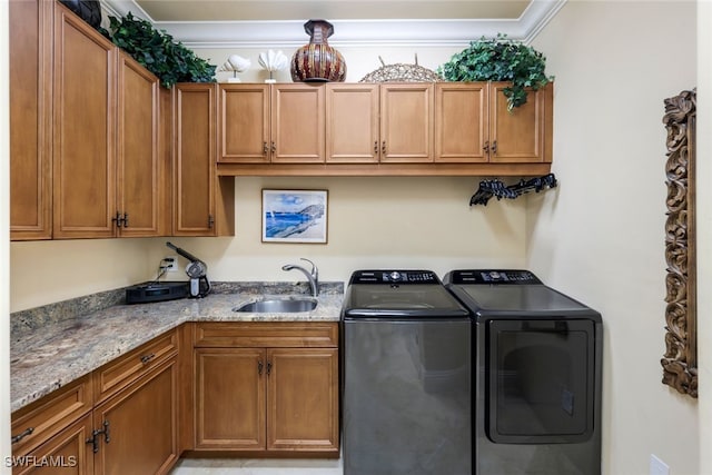 washroom with cabinets, independent washer and dryer, ornamental molding, and sink