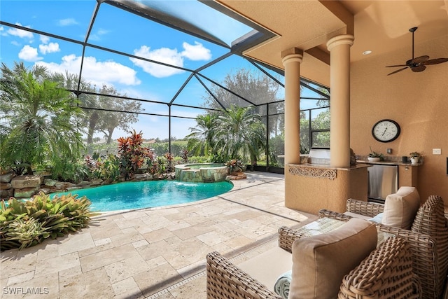 view of pool featuring an in ground hot tub, a patio area, glass enclosure, and ceiling fan