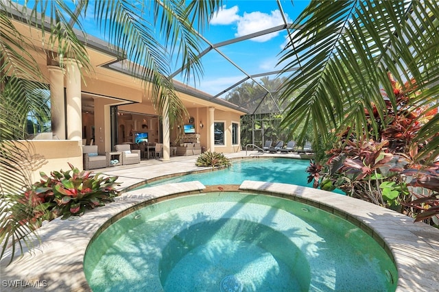 view of pool featuring an in ground hot tub, a patio area, and glass enclosure