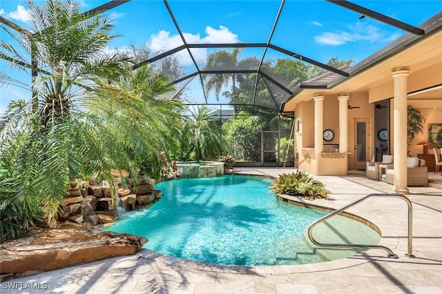 view of swimming pool with an in ground hot tub, a patio area, a lanai, ceiling fan, and pool water feature