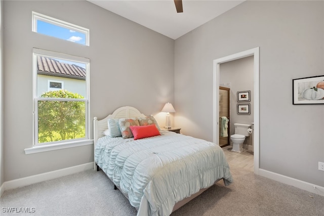 carpeted bedroom featuring ceiling fan and connected bathroom