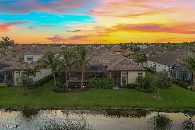 mediterranean / spanish-style house featuring a lawn and a water view